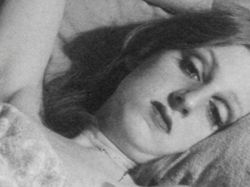 Black and white film still from Paul John’s ‘Beverley’ 2024, of a lady lying in bed.